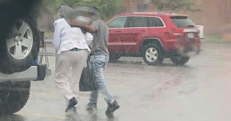 stranger-walk-elderly-woman-car-during-rain