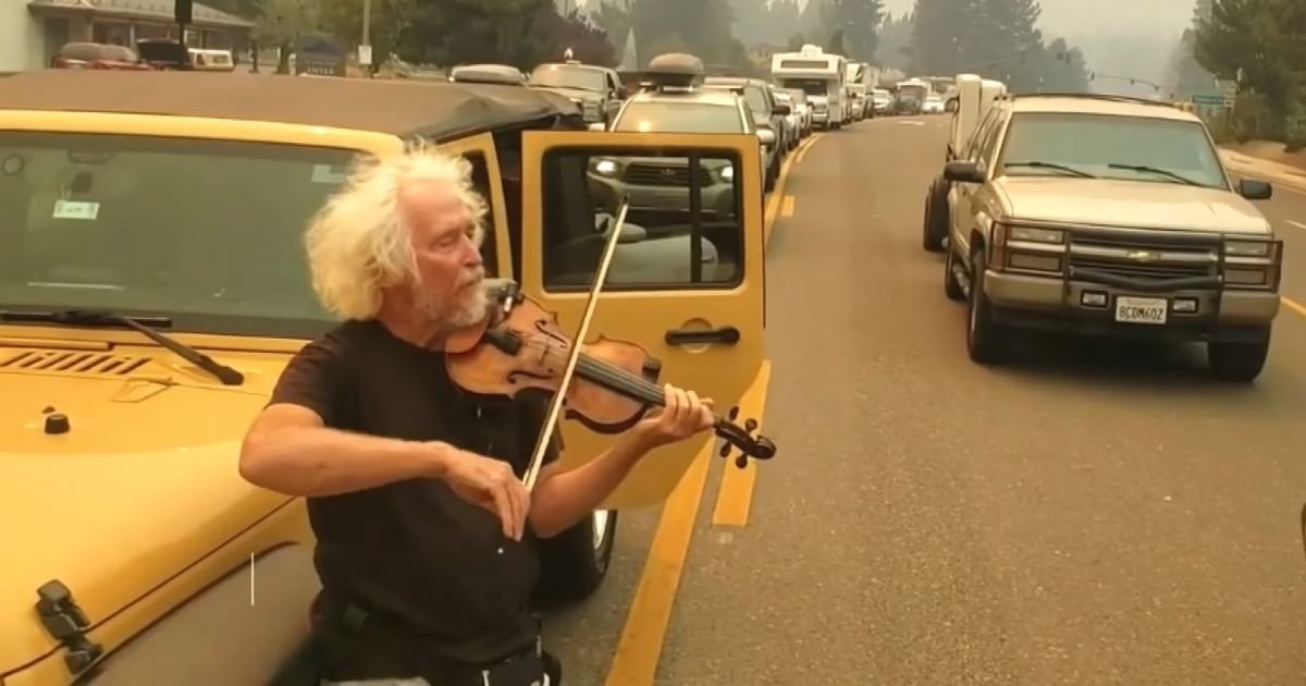 man plays violin in traffic Caldor Fire